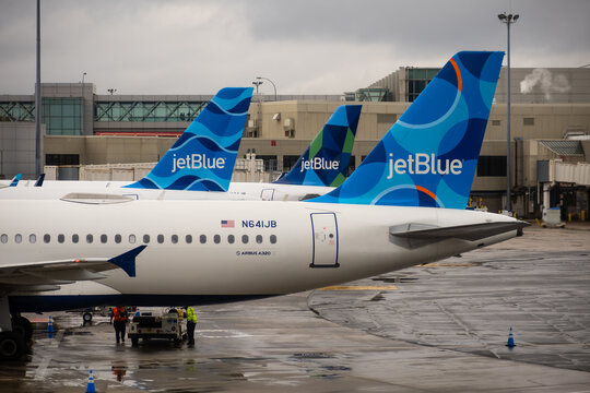 JetBlue airplanes parked at airport terminal on a cloudy day in Boston, USA.