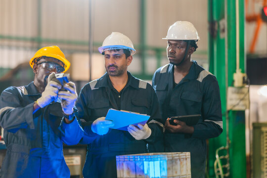 Factory technician inspecting auto parts, metal rod at machining station