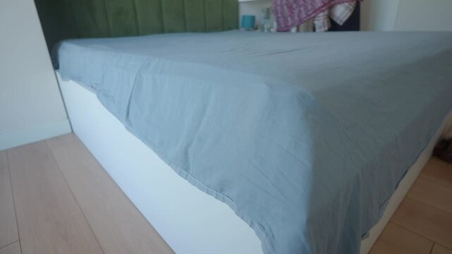 People making bed in a simple room