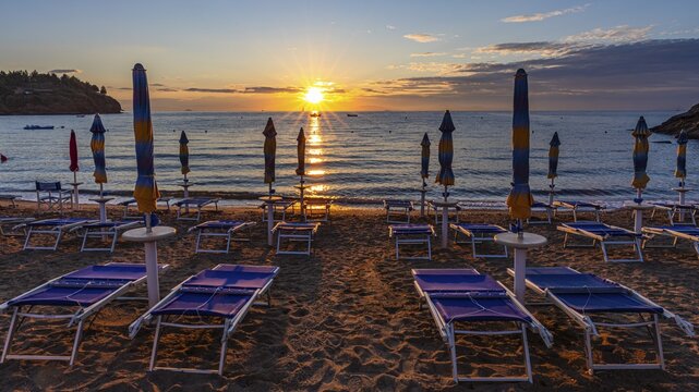 Sun loungers and parasols on Straccolignino beach at sunrise, near Capoliveri, Elba, Tuscan Archipelago, Tuscany, Italy
