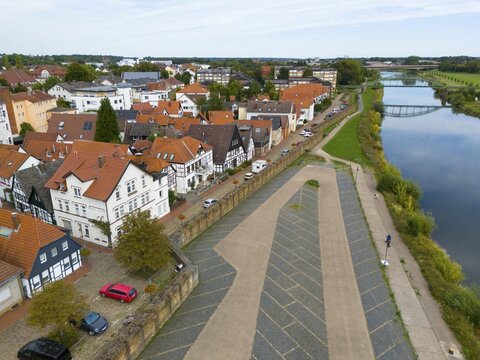 A village with half-timbered houses on the riverbank, striking red roofs and a tranquil atmosphere, seen from above, aerial view, fishing town on the Weser, Minden, North Rhine-Westphalia, Germany