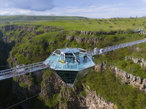 A glass platform with people stands on a bridge overlooking a green gorge, surrounded by picturesque nature, Diamond Bridge, Diamond Glass Bridge, world's longest free-hanging structure, Dashbashi Gorge, Khrami River, Tsalka Nature Reserve, Kartlia, Georgia