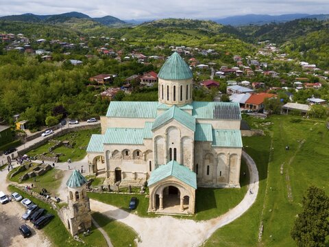 Old cathedral with green roofs in a village with mountains in the background, aerial view, Bagrati Cathedral, Church of the Dormition of the Most Holy Mother of God, UNESCO World Heritage Site, Kutaisi, Kutaisi, Imereti Region, Georgia