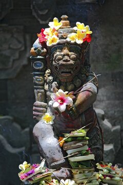 Sacred temple figure with flowers, Bali, Indonesia