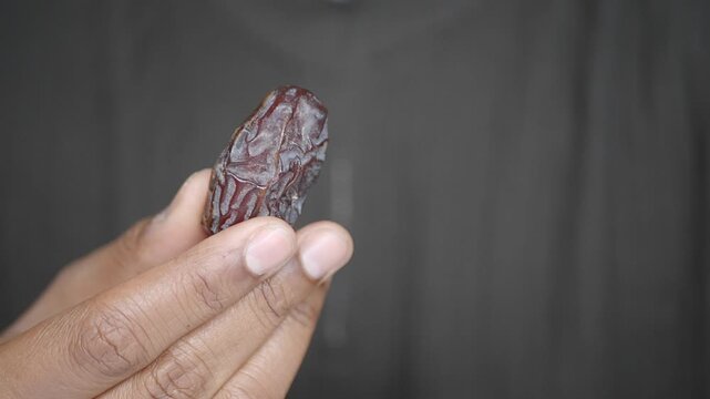 Holding a date fruit in hand during a snack time