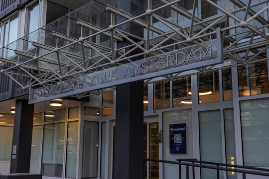 Amsterdam, Netherlands: Front entrance and glass space-frame canopy of the Scientology Church building with the official sign written in Dutch.