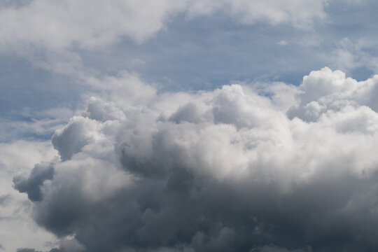 Dark cumulus banked for storm, meteorologist observing pressure change, heavy underbellies and deep shadows signal incoming thunder, cinematic tension across sky