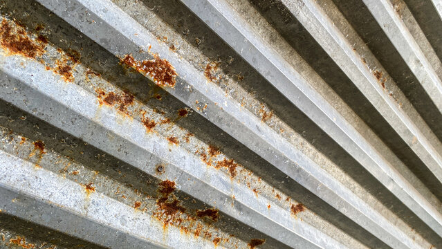 Abstract pattern texture background. Galvanized iron sheet or corrugated zinc sheet, some parts of which are rusty. Close up view of galvanized iron sheet roof or corrugated zinc sheet, geometric line