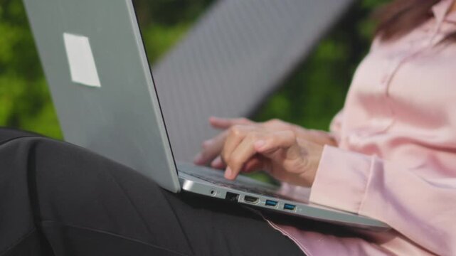 Closeup of woman hand use a laptop near by swimming pool in the morning