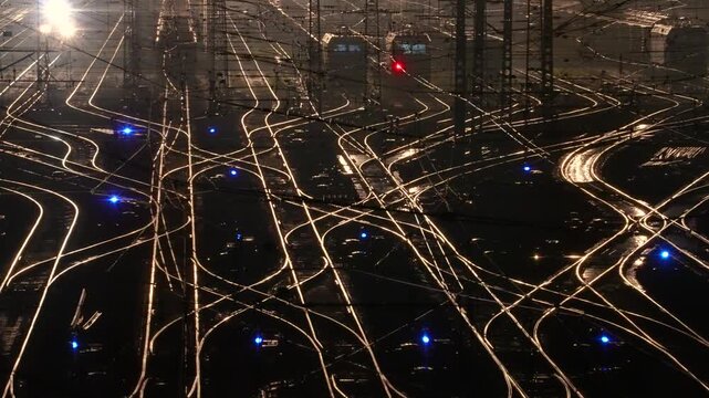 Glowing Railway Tracks and Signals in Busy Rail Yard at Night