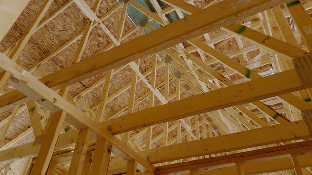 Wood framing inside a new residential house under construction with unfinished structural support beams