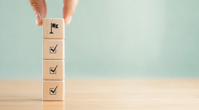 Corporate regulatory and compliance. Goals achievement and business success. Project and goals tracking. Task completion. Managing project timeline. Holding wooden cube with target achievement icon.