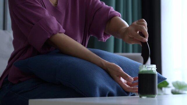 Asian mature woman using gua sha massage her arms and hands