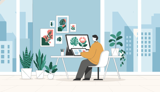 Artist working at a desk with a large computer monitor and multiple digital tablets in a modern high-rise office.