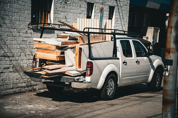 White pickup truck loaded with construction debris and building materials © Tom Harwood