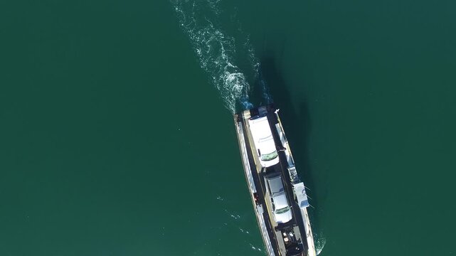 Aerial view of the Chappy Ferry carrying vehicles across the calm dark waters of the harbor in Edgartown, Massachusetts, United States.
