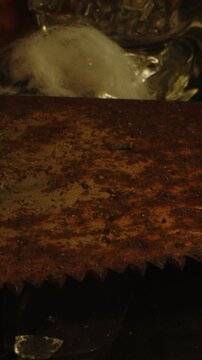 Vertical macro Dolly of a rusty and filthy saw at the base of an occult altar