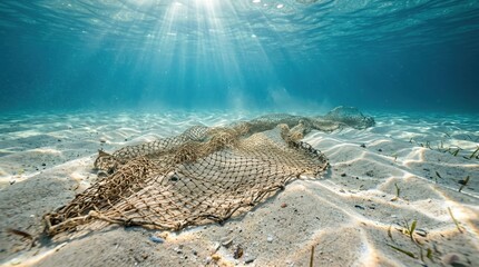 Fototapeta premium Fishing net abandoned on the seabed in clear ocean water. Overfishing, destructive fishing practices, marine pollution, bycatch, and threats to marine ecosystems concept