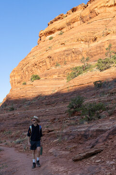 Man hikes on a sunny desert canyon trail
