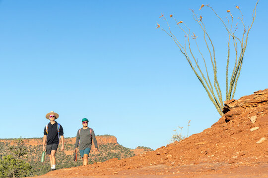 Two young men hike a desert trail together