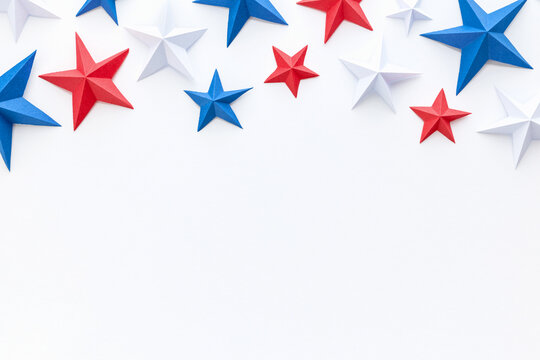 Red, white and blue origami paper stars on white background with large copy space, ideal for patriotic advertising, holiday promotions, greeting cards, invitations, banners, posters, social media