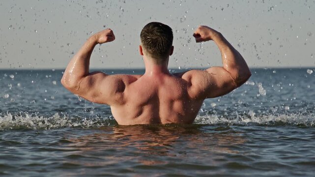 Back muscles show strong body. Back workout shape looks athletic. Shirtless back concept shows power. Wet back pose feels dynamic.