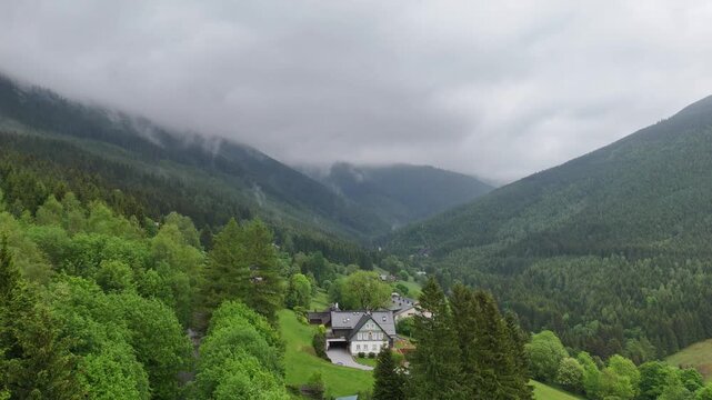 Aerial view of mountain house in misty spruce forest in Krkono&scaron;e Mountains Czech Republic