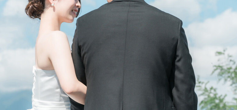 A couple with their arms linked, the bride and groom's backs, and their profiles during a wedding photoshoot.