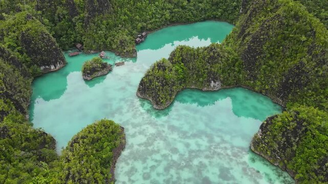 Aerial view of tropical limestone karst islands surrounded by crystal clear turquoise water in Raja Ampat