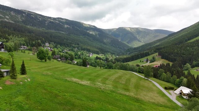 Aerial view of mountain valley with spruce forest and village in Krkono&scaron;e Mountains Czech Republic in summer