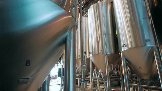 Steel fermentation tanks and brewing equipment inside a modern craft brewery production facility