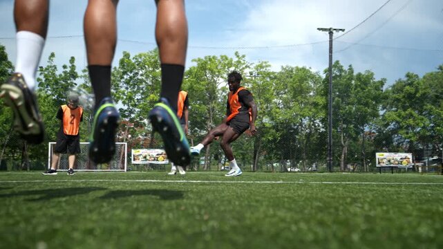 Soccer players jumped together during training to practice defensive tactics by forming a wall to protect the goal from free kicks. This demonstrates teamwork and athletic performance on the field