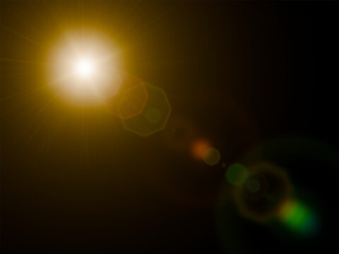 Bright golden sun lens flare with polygonal bokeh ghosts isolated on black background.