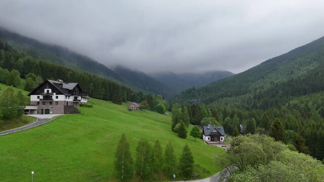 Aerial view of a misty mountain valley with spruce forest and scattered cottages in Krkono&scaron;e Czech Republic