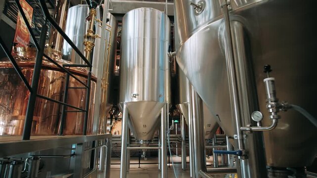 Steel fermenters and copper vats inside a modern craft beer brewery for ale and lager production