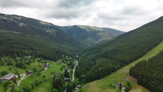 Aerial view of mountain valley with spruce forest and village in Krkono&scaron;e Mountains Czech Republic in summer
