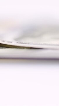 Low angle stacked dollar edges drifting along surface, auditor inspects subtle folds and paper layers, soft blur horizon and clinical lighting, calm transactional composition