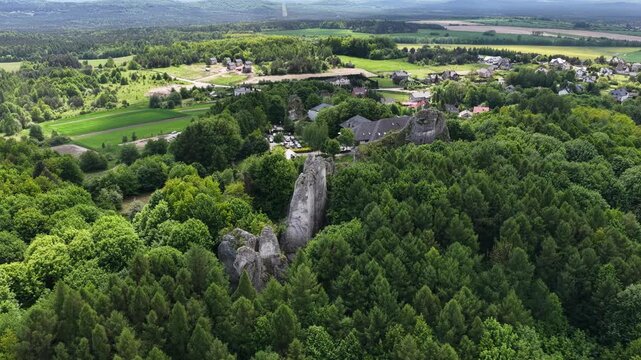 Aerial drone view of Ogrodzieniec and Podzamcze in southern Poland during spring, showcasing historic market square, village landscape, ponds and the Jura countryside scenery