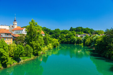 Obraz premium Skyline of town of Novo Mesto, mirrored in Krka river, Slovenia
