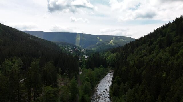 Aerial view of country road through green valley with mountains in Poland