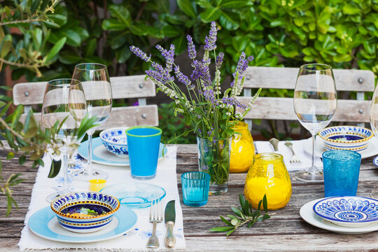 Garden table laid with colorful plates and bowls