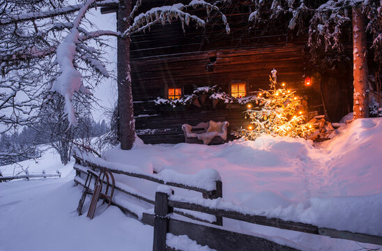 Wooden house with Christmas tree in winter landscape