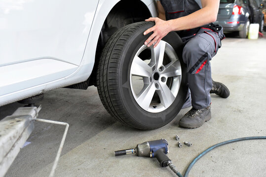 Car mechanic in a workshop changing car tyre
