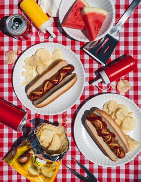 Summer picnic flat lay with hot dogs and watermelon on sunny day.