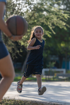 Young girl playing basketball outdoors