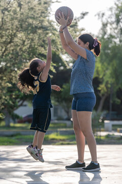 Young girl reaching to block a basketball shot