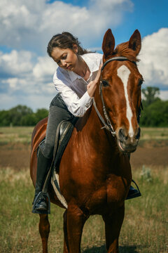Woman on horse, looking away, sunny day, outdoor