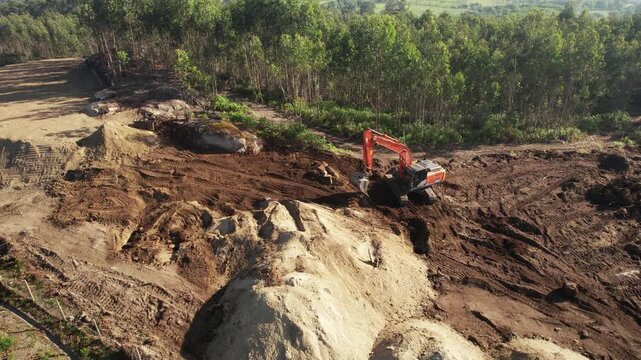 Drone footage capturing an excavator operating on a hillside