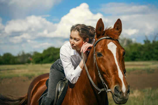 Woman on horse, looking away, sunny day, outdoor