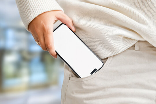 Person sliding blank screen smartphone into pocket